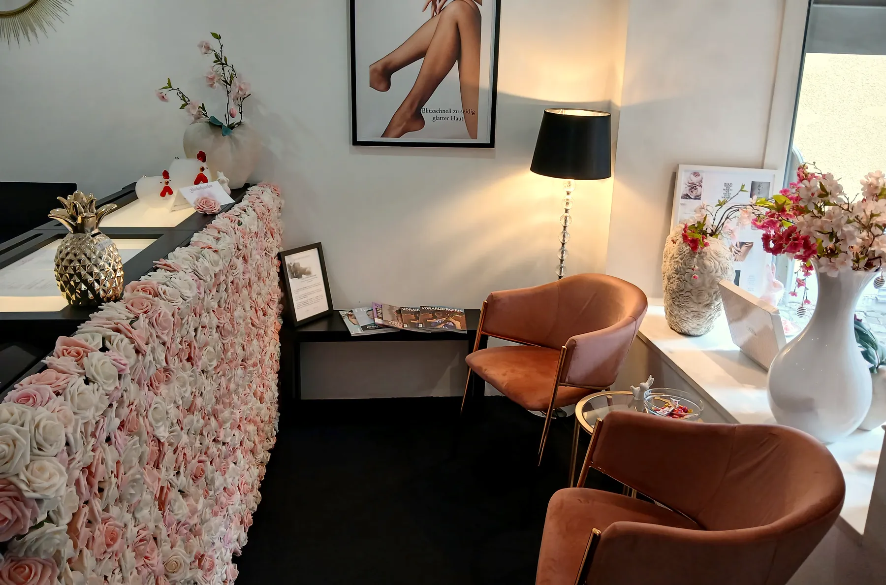 Wartebereich mit zwei rosé Samtsesseln, Stehlampe und Blumen am Fenster